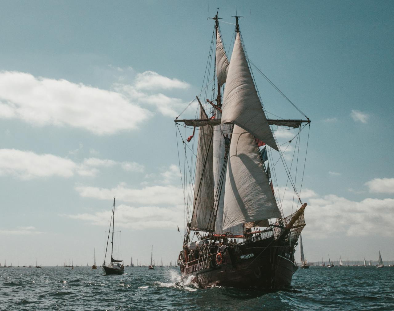 A breathtaking sailing ship glides through the Falmouth sea under a clear blue sky.