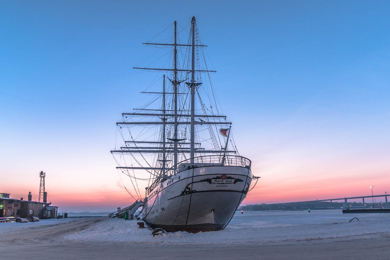 Captivating sunset view of a historic ship docked at Stralsund harbor, Germany.